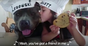 Schattiger wordt het niet: lief meisje zingt voor haar grote vriend pitbull vriendje