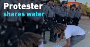 Donkere demonstrant laat zien hoe het ook kan en geeft water aan politieagenten