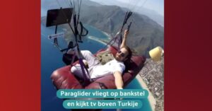 Doldwaze paraglider vliegt met een compleet bankstel hoog door de lucht