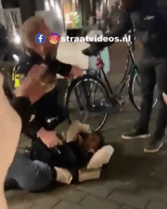 Politieagent pakt de al op de grond liggende dame hard aan